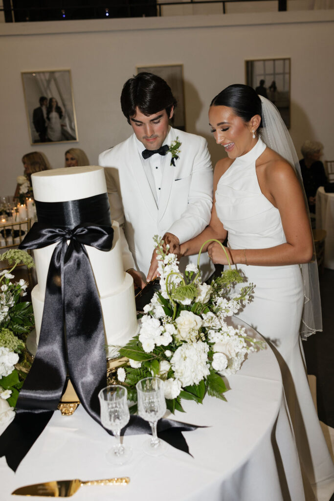 bride and groom cut the wedding cake during their wedding reception