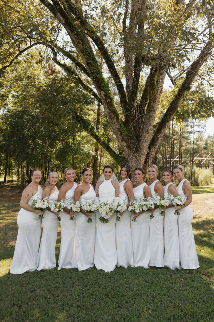 bride with her bridesmaids all wearing white dresses