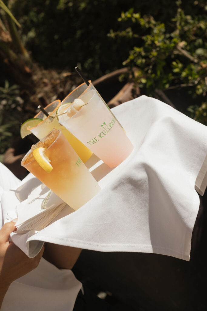 A tray with refreshing cocktails, each garnished with fruit, labeled with "The Kulbergs."