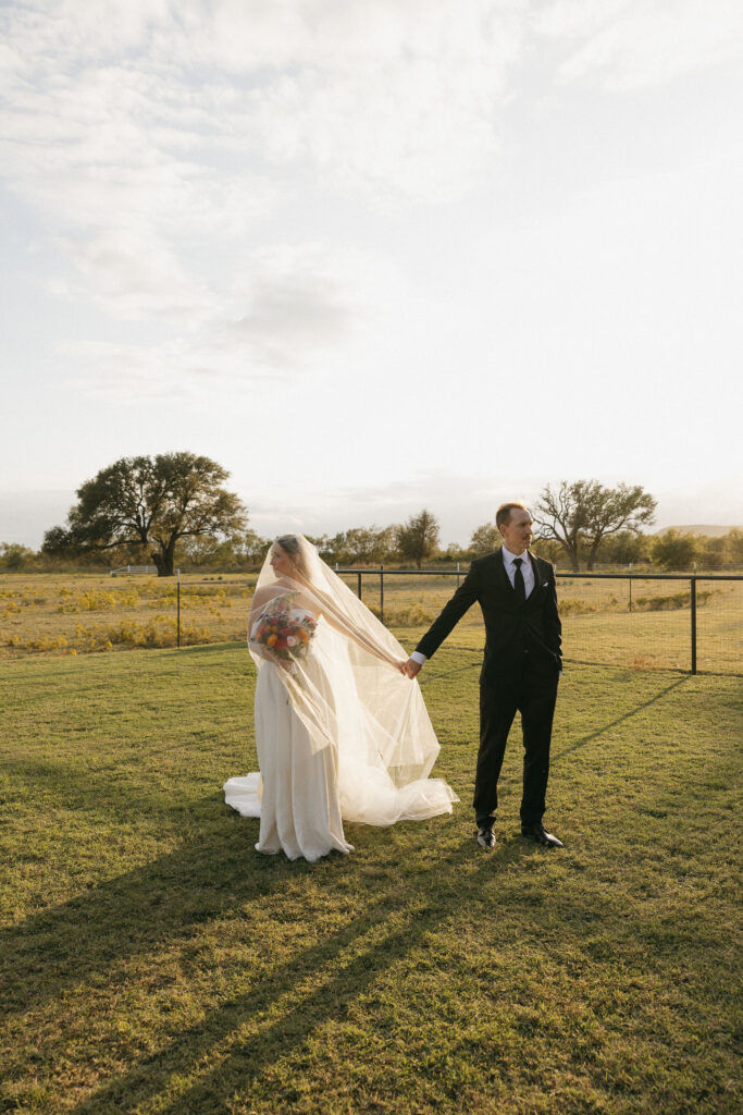 A bride and groom holding hands during golden hour