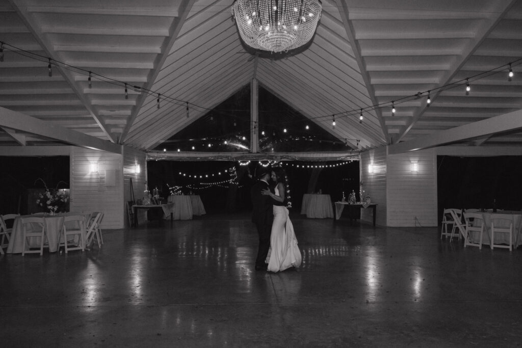 The couple shares a romantic last dance under a chandelier-lit pavilion adorned with string lights, capturing a serene evening at The Winfield Inn.