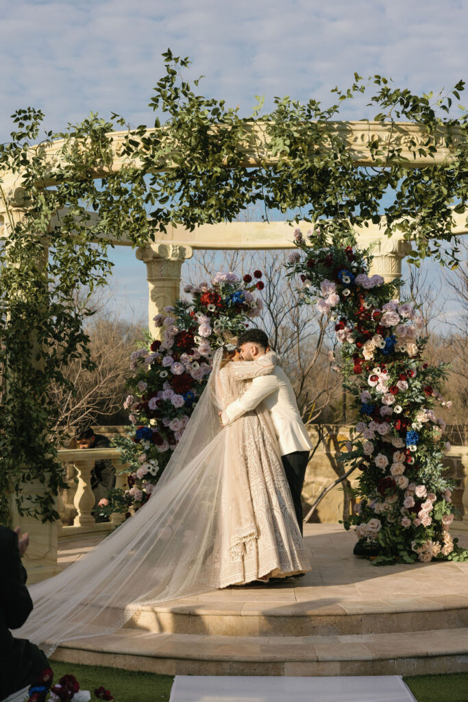 The first kiss and bride and groom during their outdoor wedding ceremony