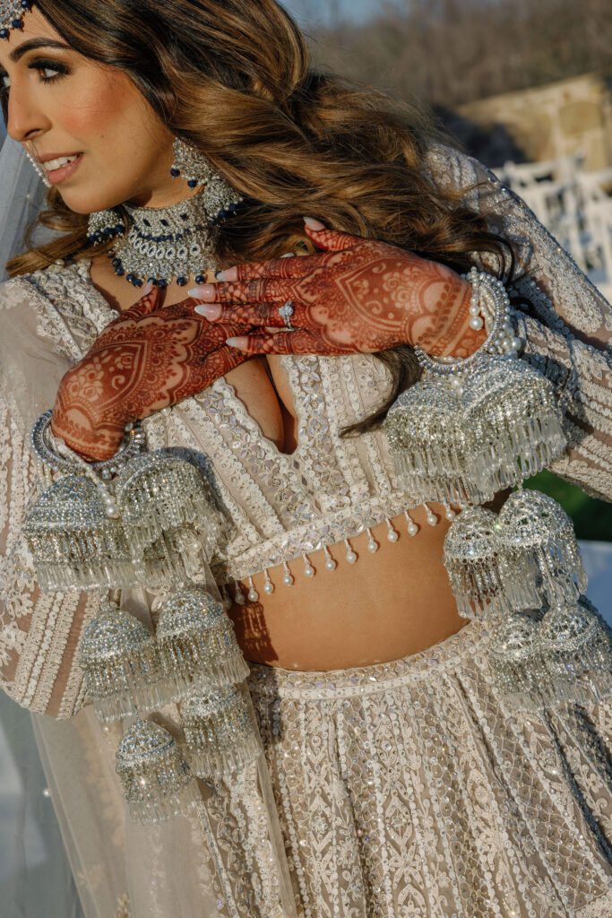 A bride wearing her traditional wedding day jewelry showing off her henna 