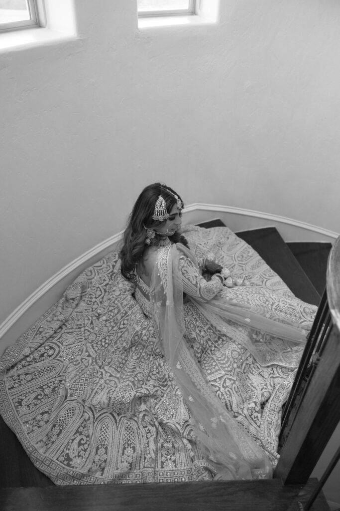 A bride sitting on the stairs in her wedding dress