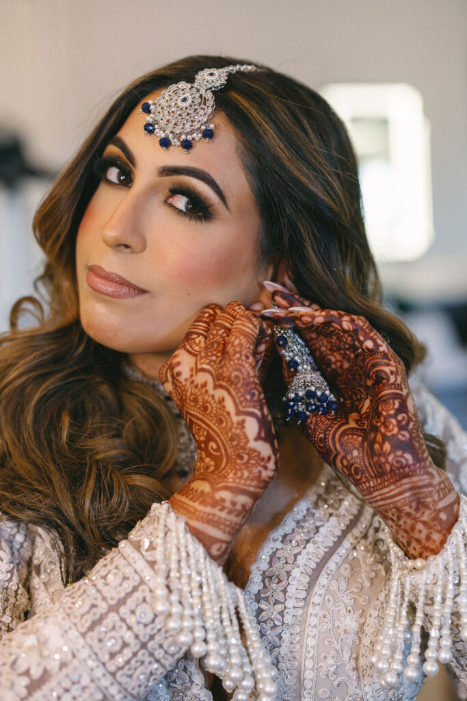 A bride putting on her wedding earrings