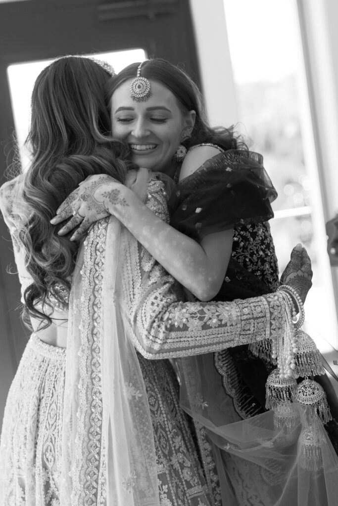 A bridesmaid hugging the bride