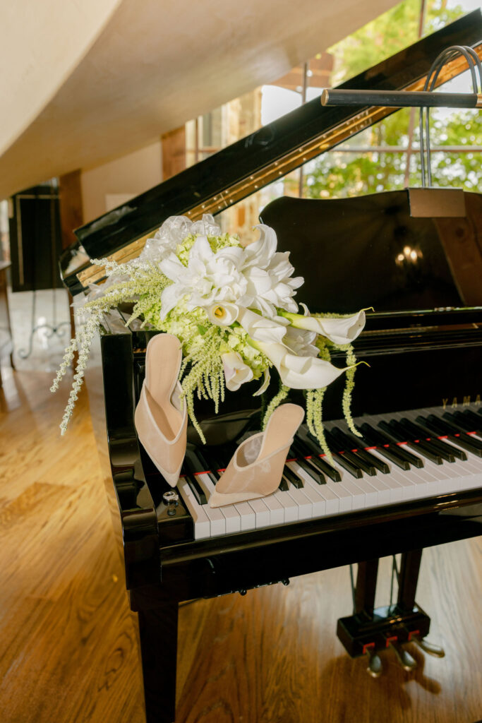 Bridal shoes and bridal bouquet on a grand piano