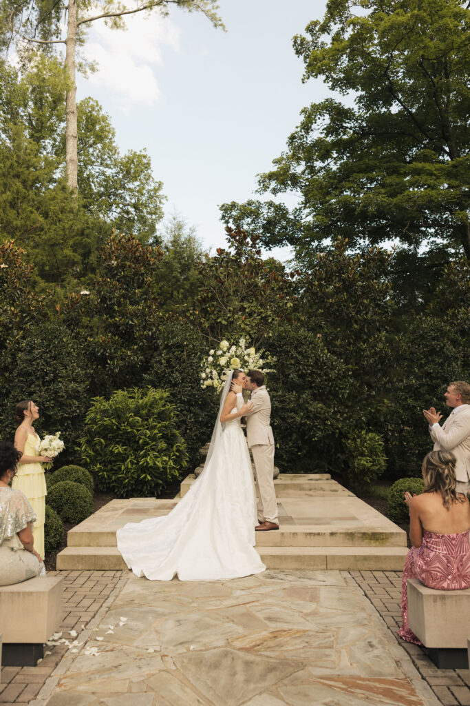 4th of july wedding in nashville bride and broom kissing with trees behind them