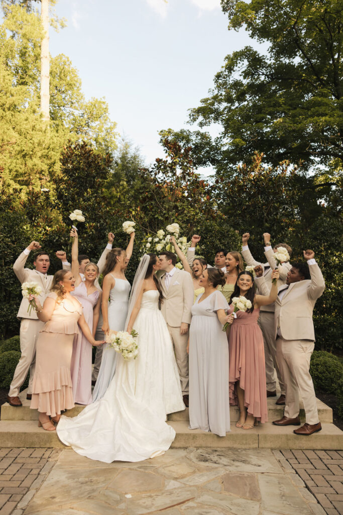 bride and groom kissing surrounded by friends in nashville