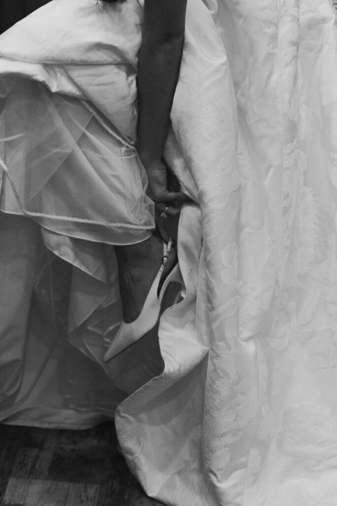black and white bride putting on wedding shoes