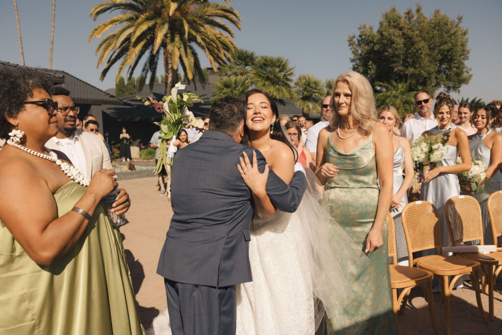 bride hugging father at wedding ceremony