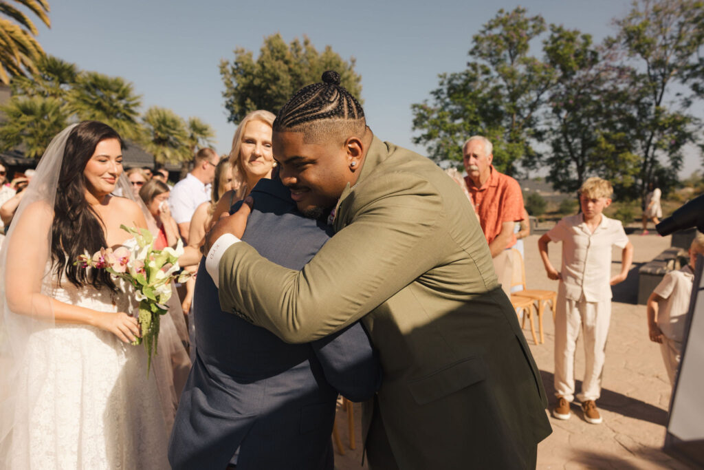 groom hugging father at wedding ceremony