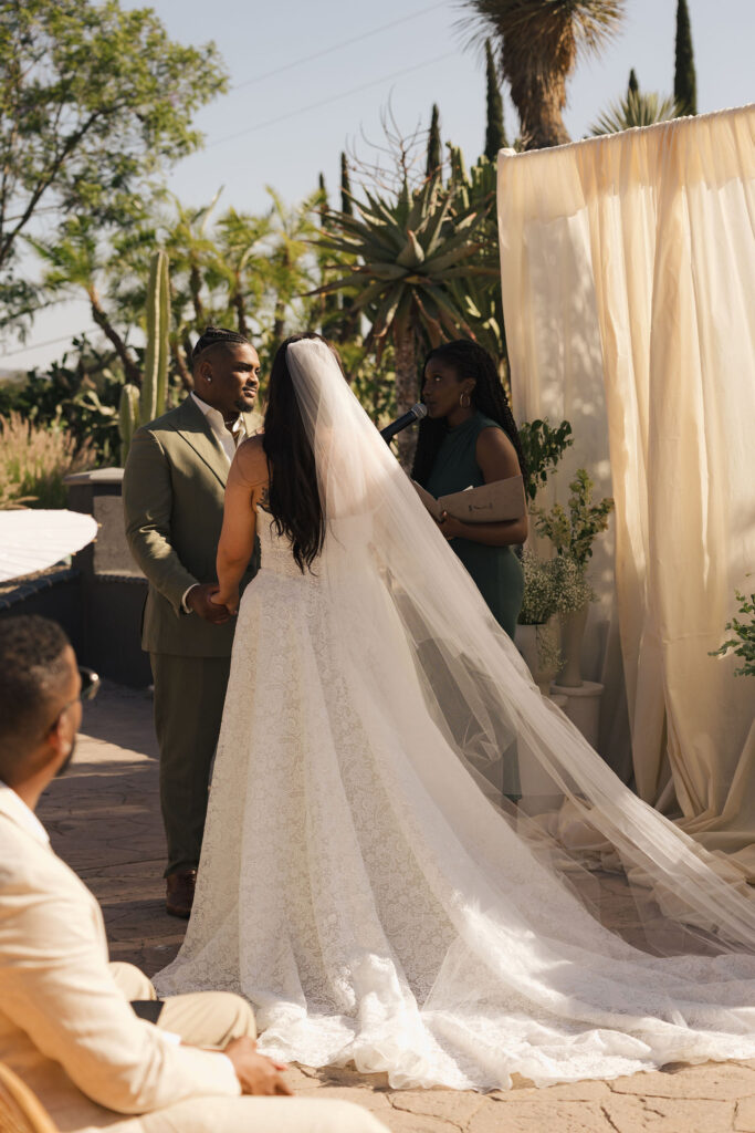 bride in wedding gown and veil at ceremony