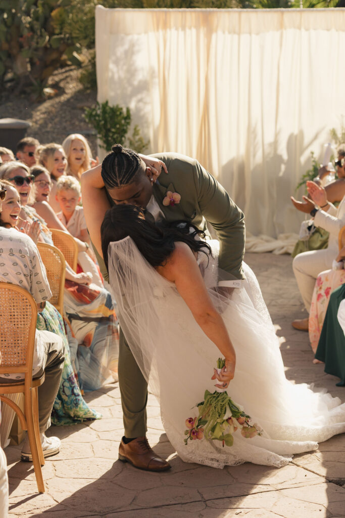 bride and groom kiss in the isle at wedding in san diego