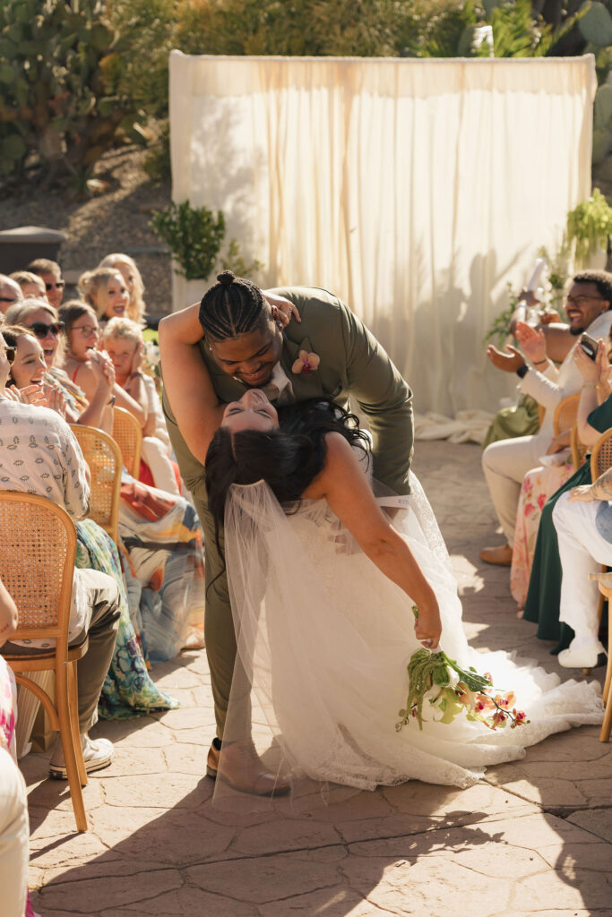 bride and groom kiss in the isle at wedding in california