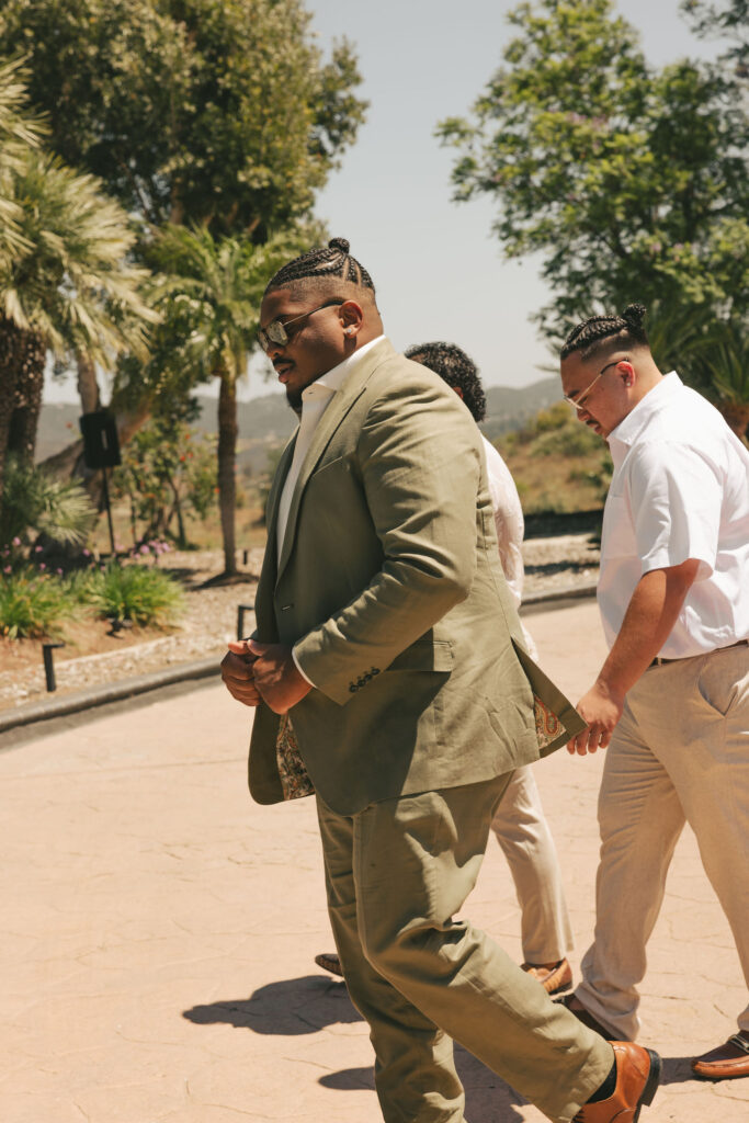 groom walking with friends on wedding day in california