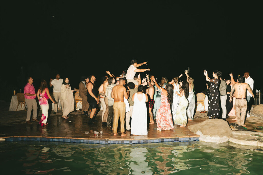 friends having fun at wedding in front of pool