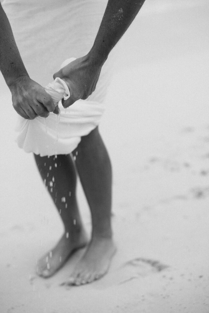 black and white photo of bride dress on beach
