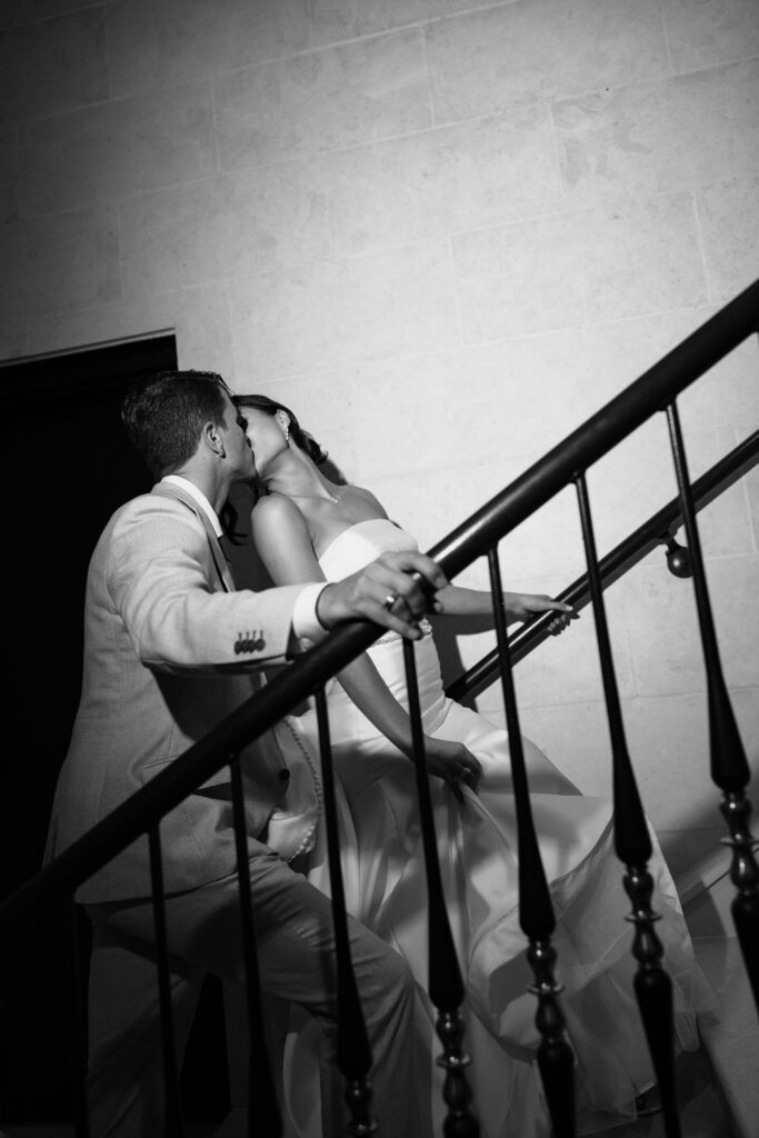 bride and groom kissing on stairs