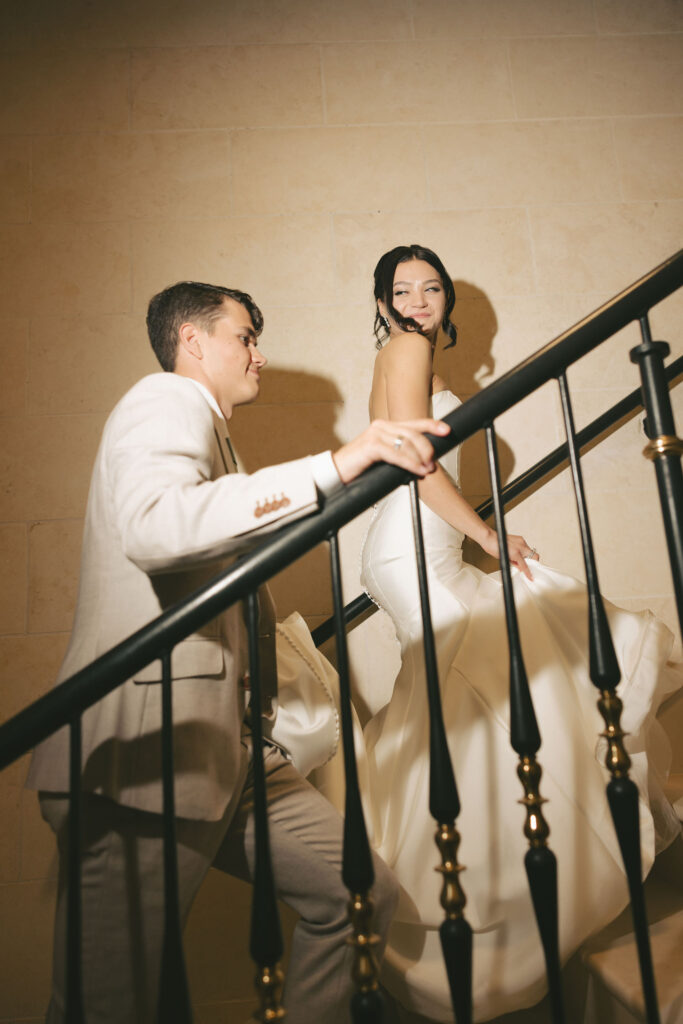 bride and groom walking up stairs