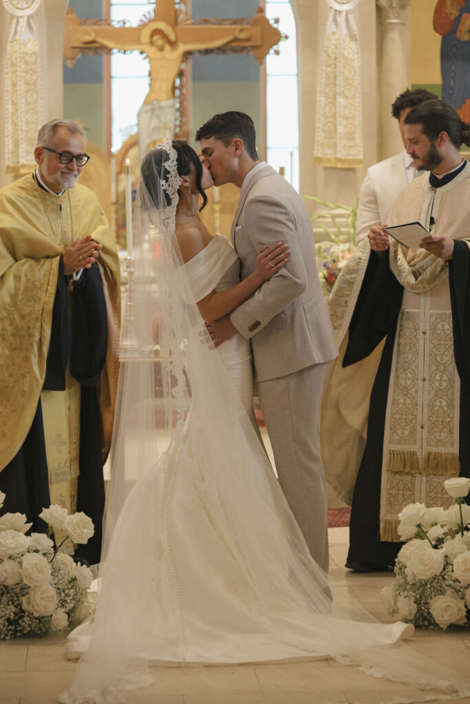 bride and groom first kiss in greek orthodox church