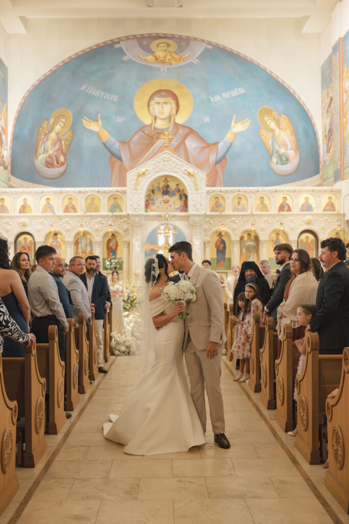 bride and groom kiss in greek orthodox church