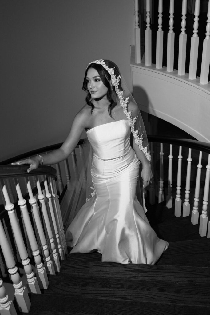 bride with veil walking up stairs