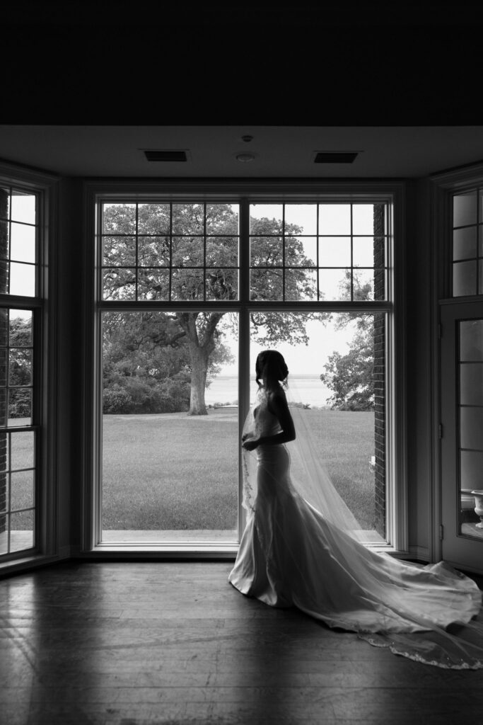black and white image of bride in front of windows