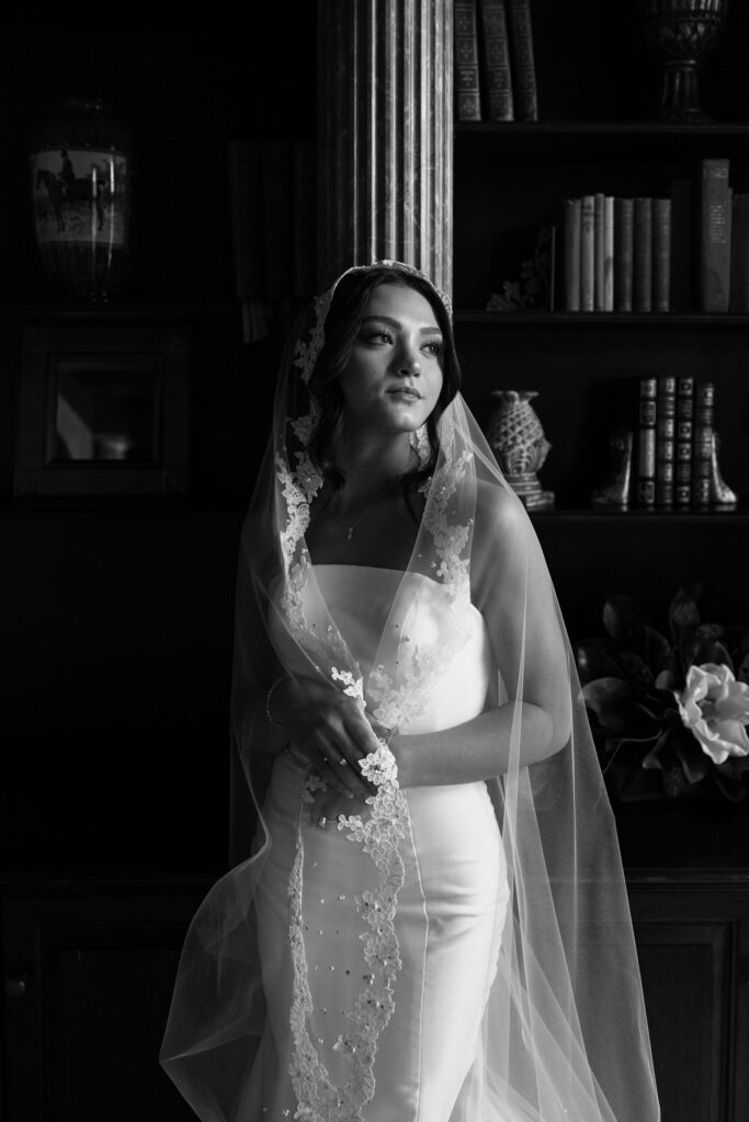 black and white image of bride with veil wrapped around herself
