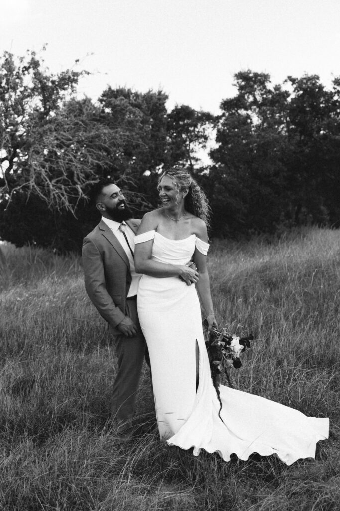 bride and groom in field black and white