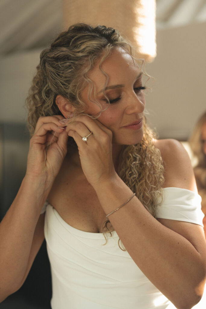 bride putting on earrings