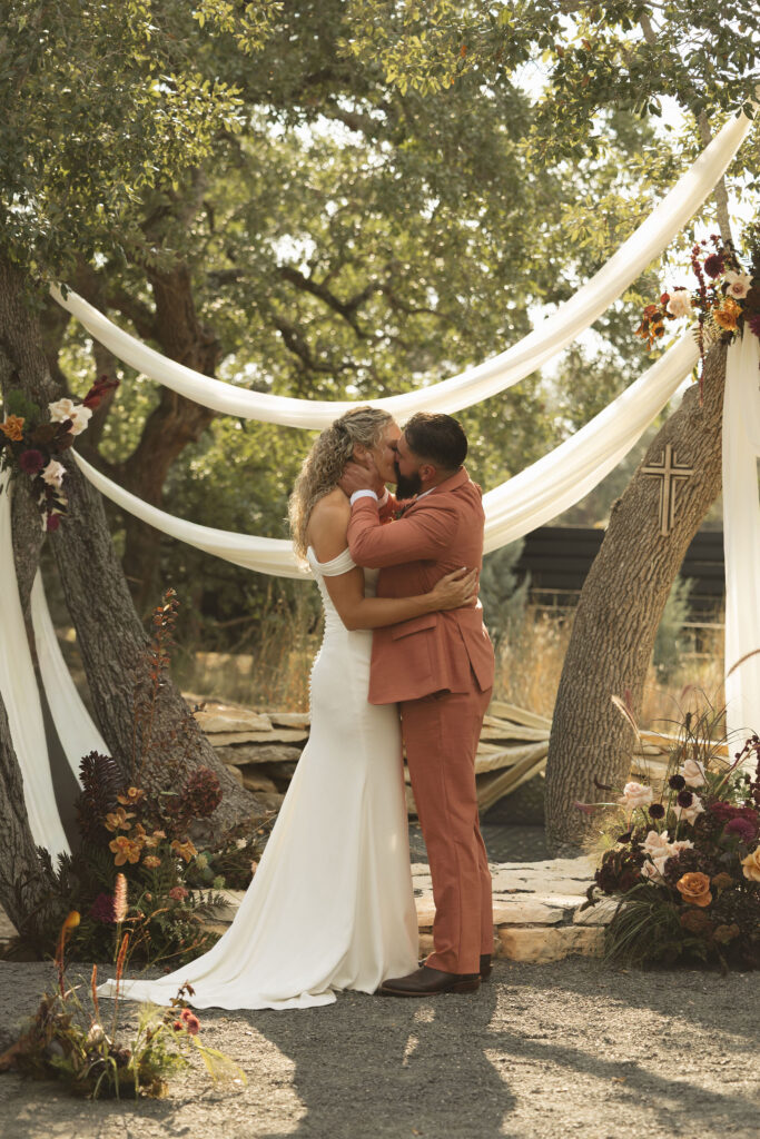 bride and groom first kiss at the cedars ranch